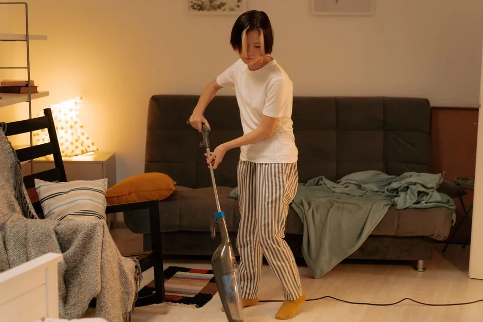 Couple heureux installant un canapé dans leur nouveau logement, entouré de cartons de déménagement.